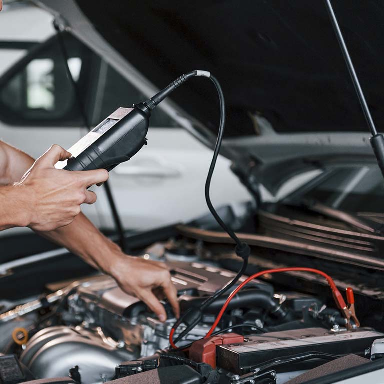 Hombre verificando sistema eléctrico de coche